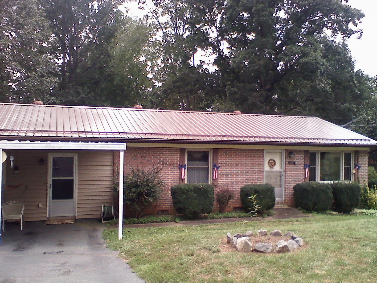 Bronze metal roof and carport on a brick ranch home — Roof Repair work by our crew in New Weston